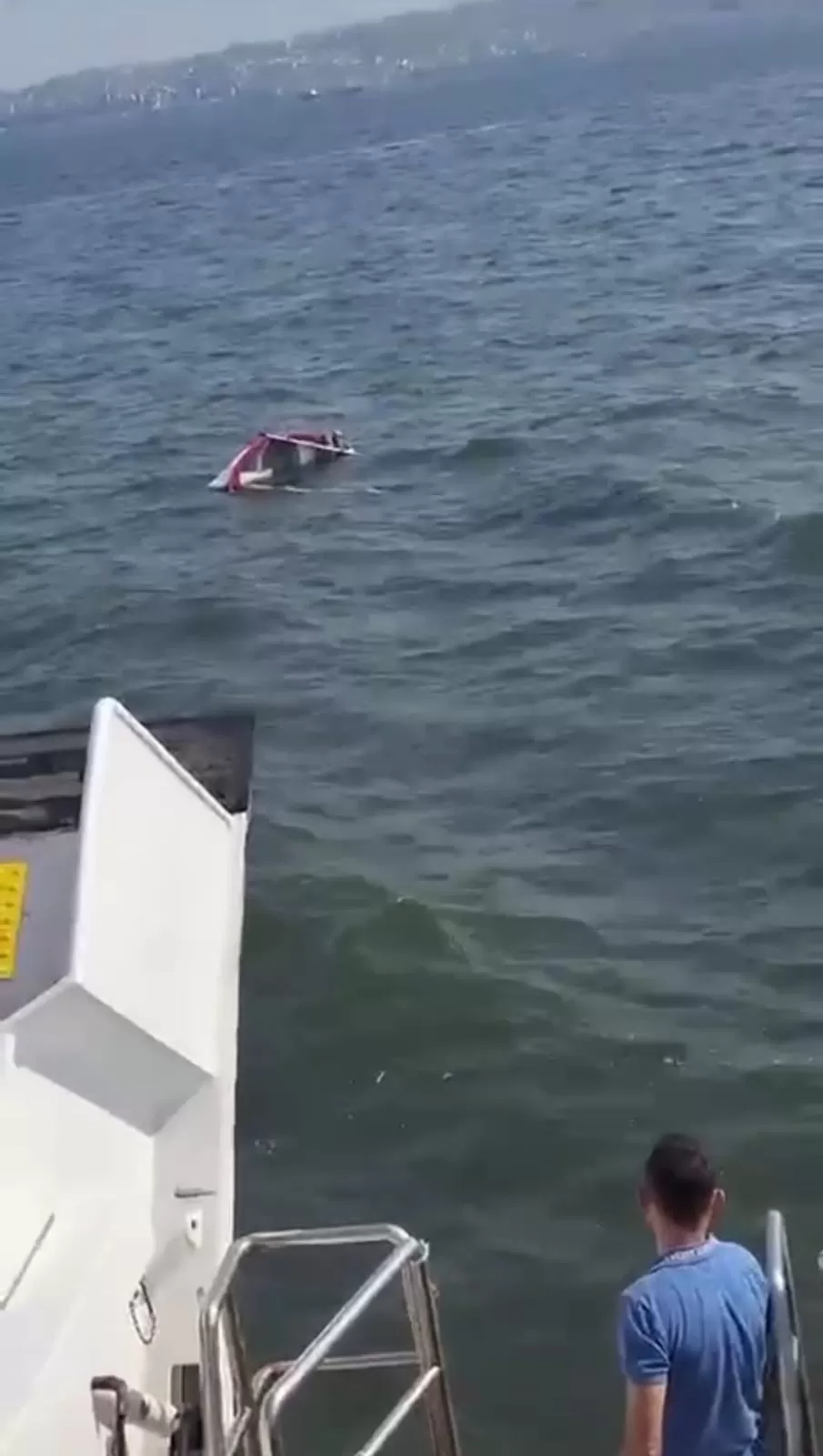 İzmir Körfezi’nde teknesi alabora olan amatör denizcinin kurtarılma anı cep telefonu kamerasına yansıdı.